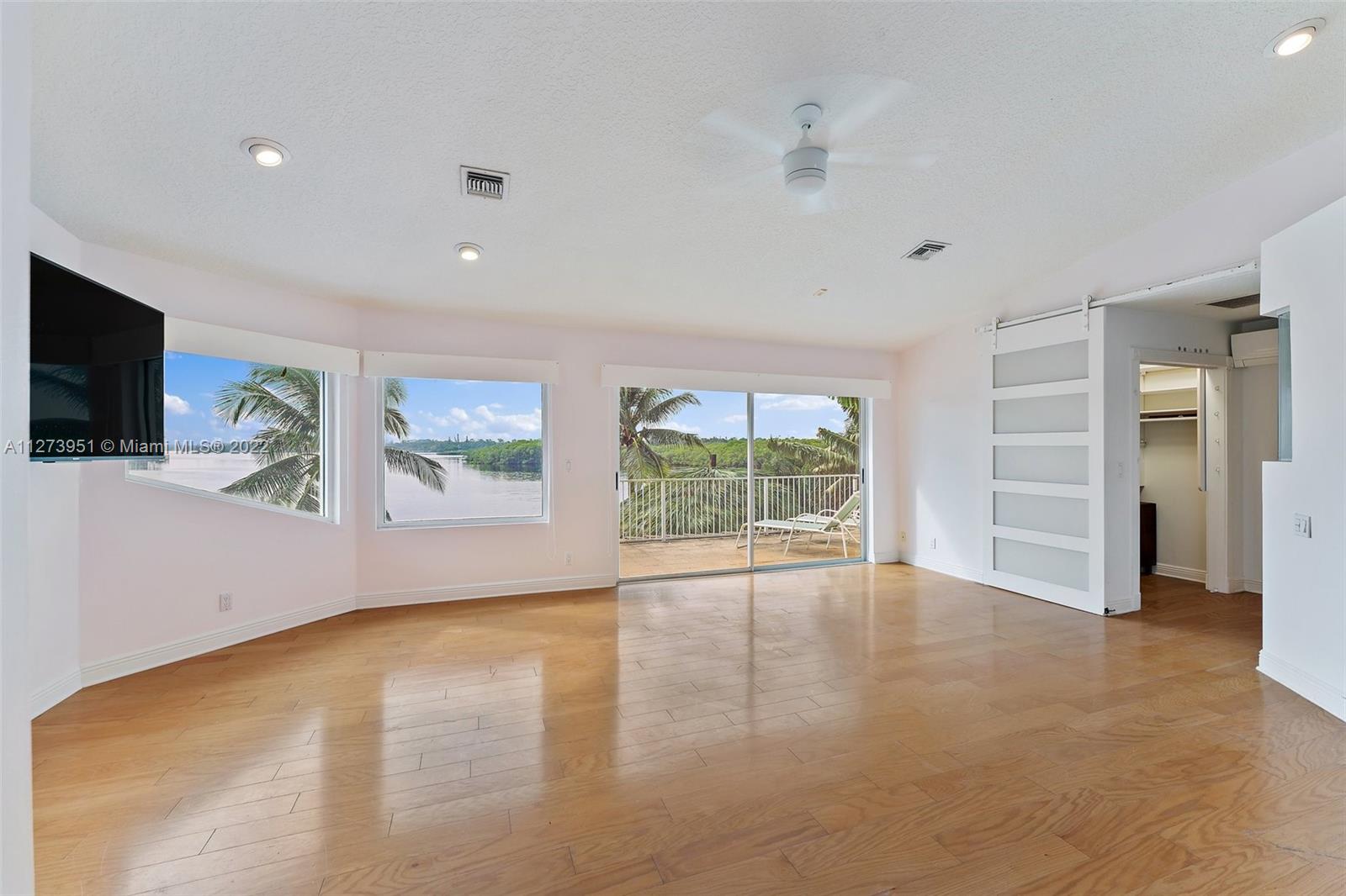 9460 Southeast Point Terrace Jupiter, FL 33469 - Photo 17 of 51 an empty room with window and flat screen tv