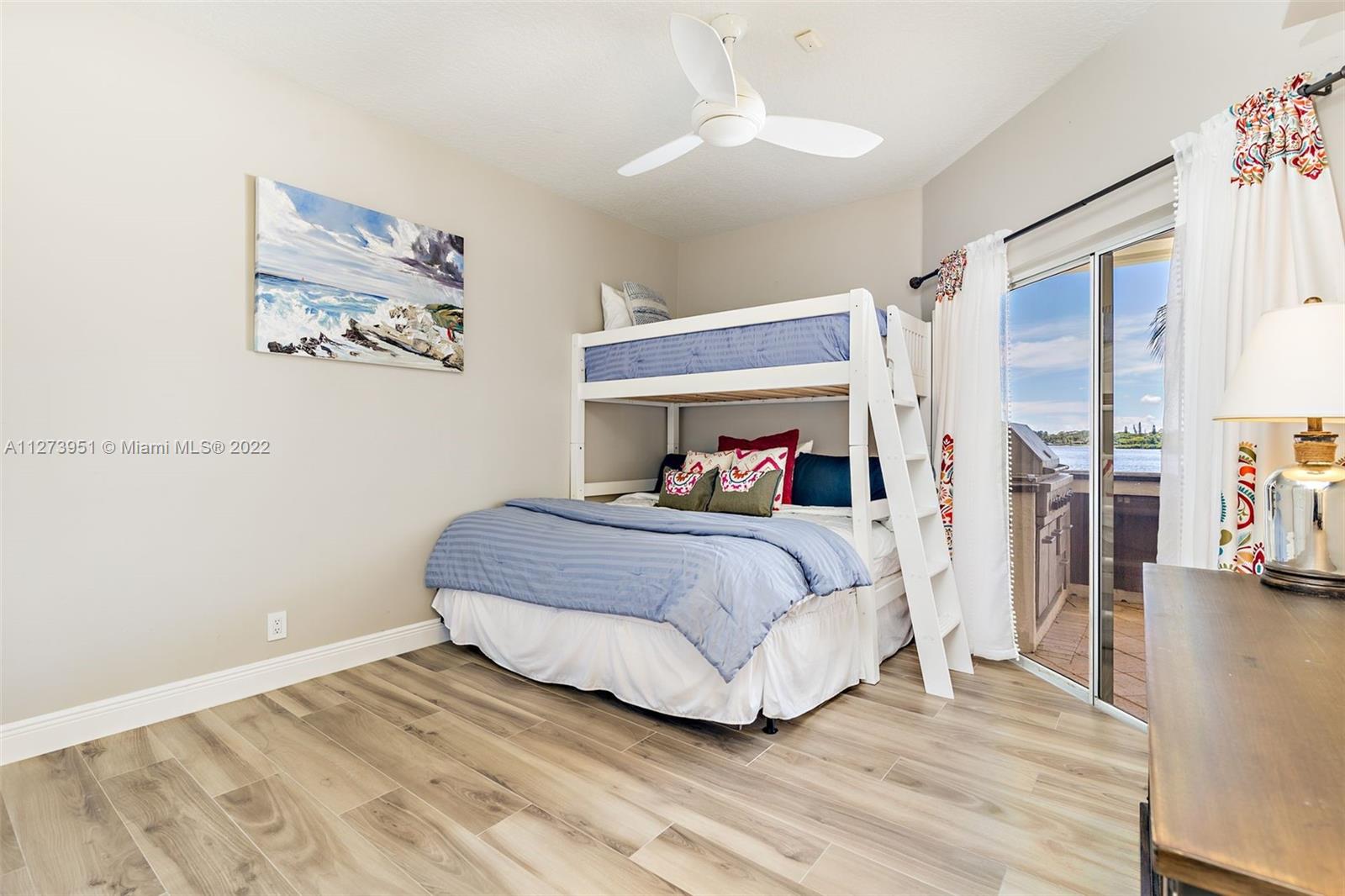 9460 Southeast Point Terrace Jupiter, FL 33469 - Photo 24 of 51 a bedroom with a bed and a chandelier