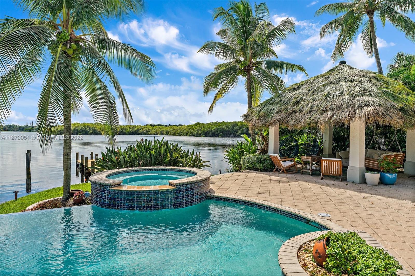 9460 Southeast Point Terrace Jupiter, FL 33469 - Photo 36 of 51 a view of a swimming pool with a table and chairs