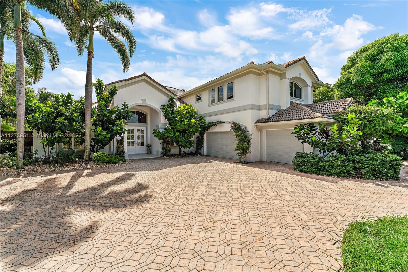 9460 Southeast Point Terrace Jupiter, FL 33469 - Photo 5 of 51 a view of a white house with a yard and potted plants