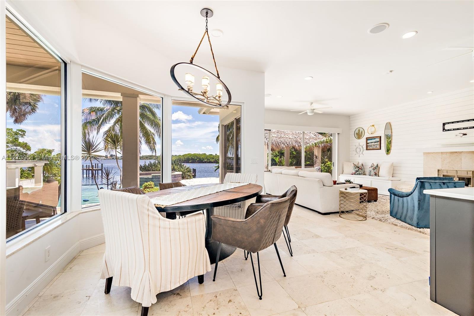 9460 Southeast Point Terrace Jupiter, FL 33469 - Photo 10 of 51 a dining room with furniture a chandelier and wooden floor