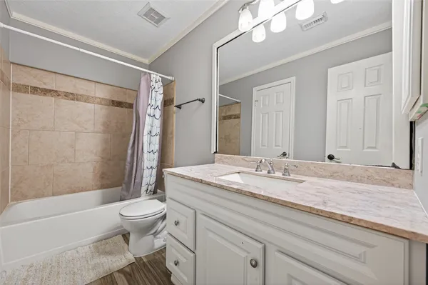 a bathroom with a granite countertop sink toilet mirror and bathtub