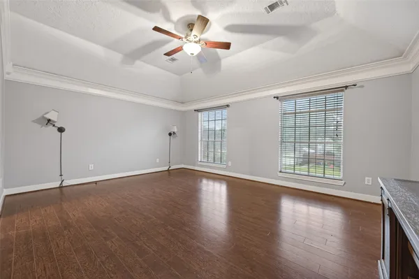 a view of an empty room with a window and wooden floor
