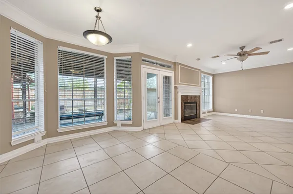 a view of an empty room with a fireplace and windows