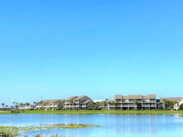a view of an ocean with boats and trees in the background