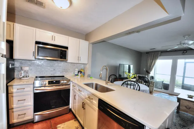 a kitchen with a sink a stove a microwave and cabinets