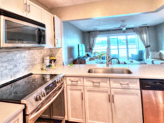 a kitchen with stainless steel appliances granite countertop a sink and a microwave
