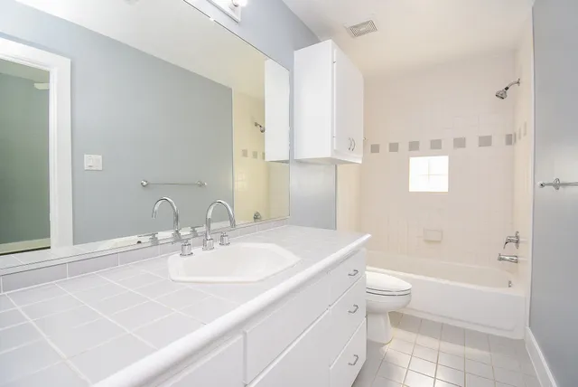 a bathroom with a sink toilet tub and shower