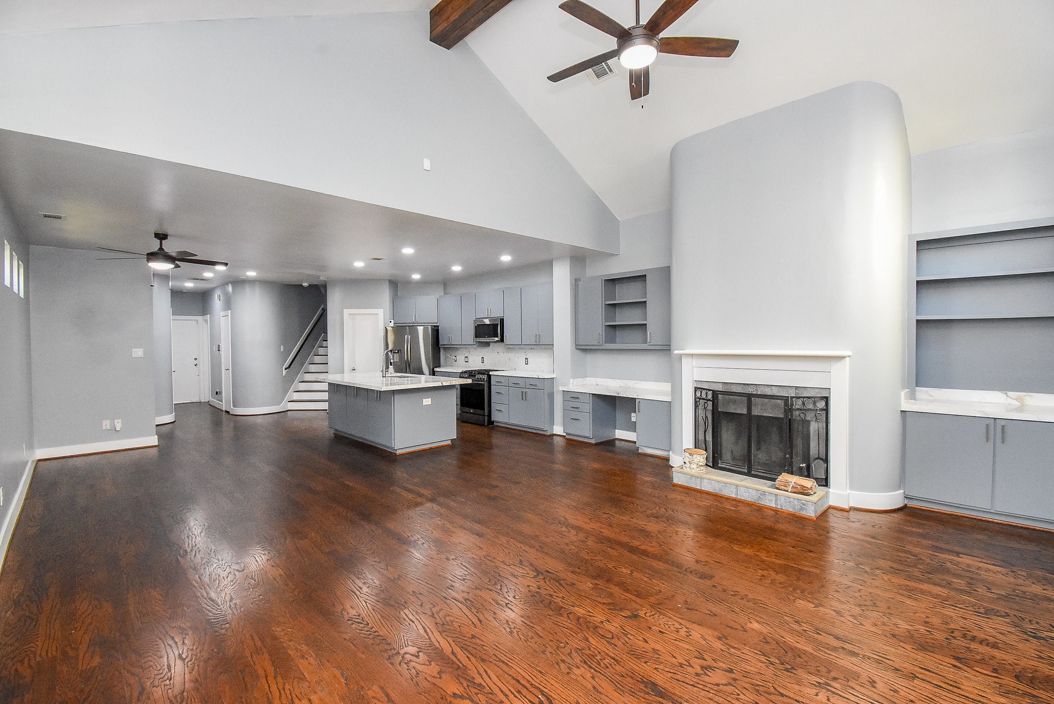 3720 Link Valley Houston, TX 77025 - Photo 7 of 25 a view of a kitchen with a stove a fireplace a ceiling fan and wooden floor