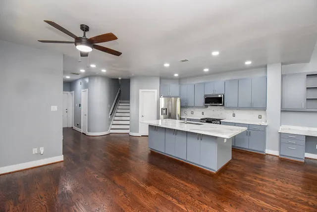 a open kitchen with cabinets and wooden floor
