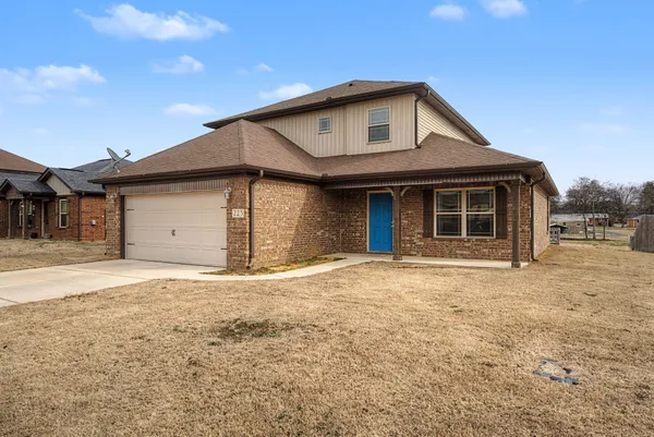 a front view of a house with a yard and garage