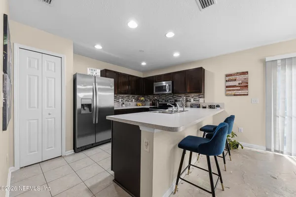 a kitchen with stainless steel appliances wooden cabinets a sink and a refrigerator