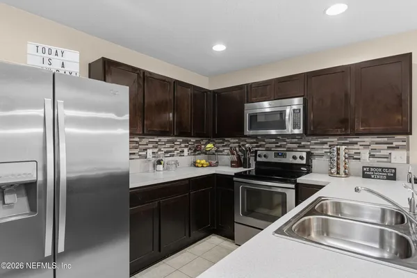 a kitchen with stainless steel appliances stove microwave sink and cabinets