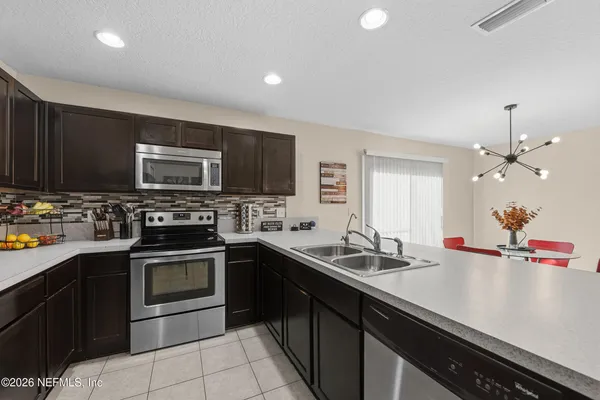 a kitchen with stainless steel appliances granite countertop a refrigerator and a sink