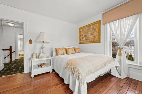 a bedroom with a bed and a large window