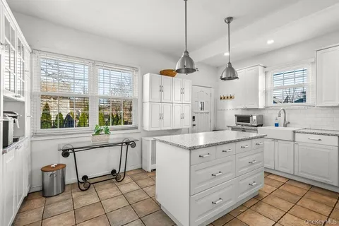 a kitchen with a sink stove and white cabinets