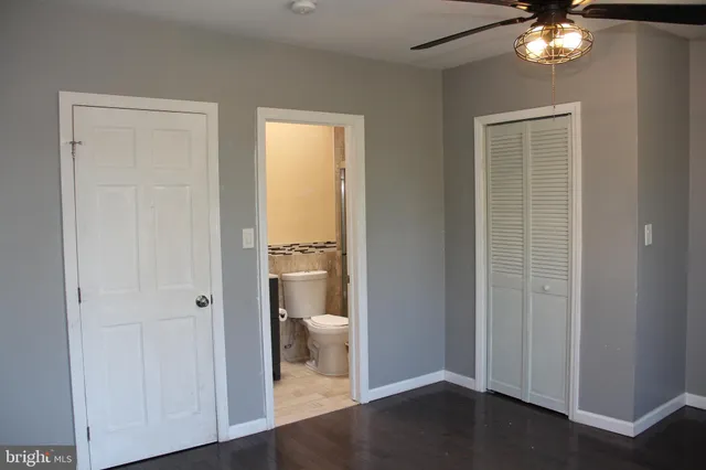 a view of a room with wooden floor closet and a bathroom