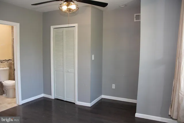 wooden floor in an empty room with a bathroom