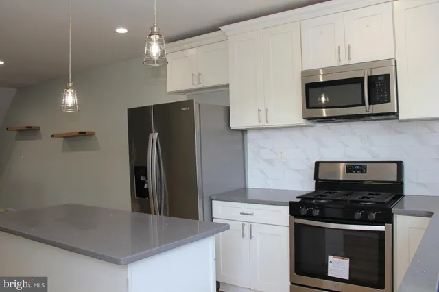 a kitchen with stainless steel appliances a stove microwave and sink
