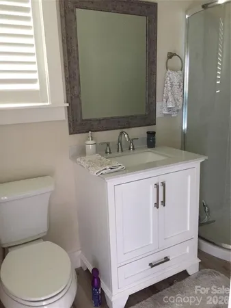 a bathroom with a granite countertop toilet sink and mirror