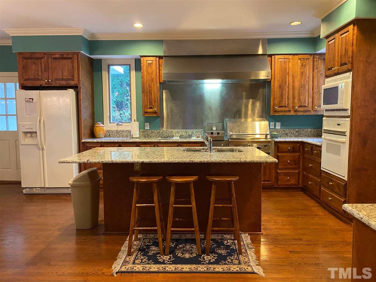3904 Hemsbury Way Raleigh, NC 27612 - Photo 9 of 20 a kitchen with wooden cabinets and a refrigerator
