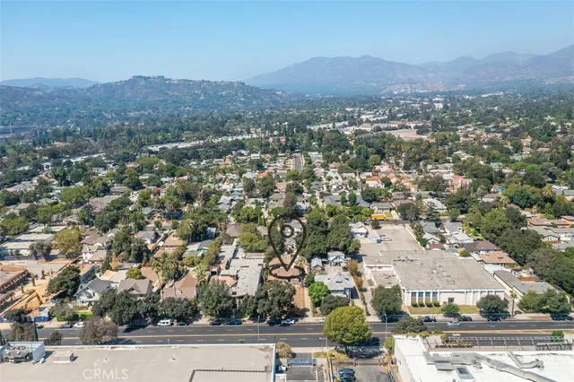 an aerial view of residential houses with outdoor space and trees