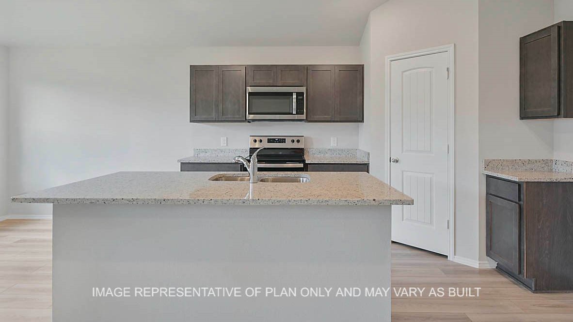 5538 Harriet Street Bryan, TX 77807 - Photo 3 of 17 a kitchen with stainless steel appliances granite countertop a sink a microwave a refrigerator and white cabinets