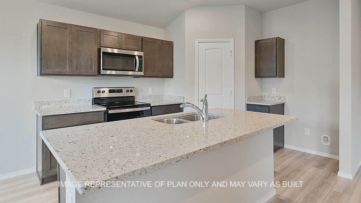 5538 Harriet Street Bryan, TX 77807 - Photo 4 of 17 a kitchen with granite countertop a sink a stove top oven and wooden floor