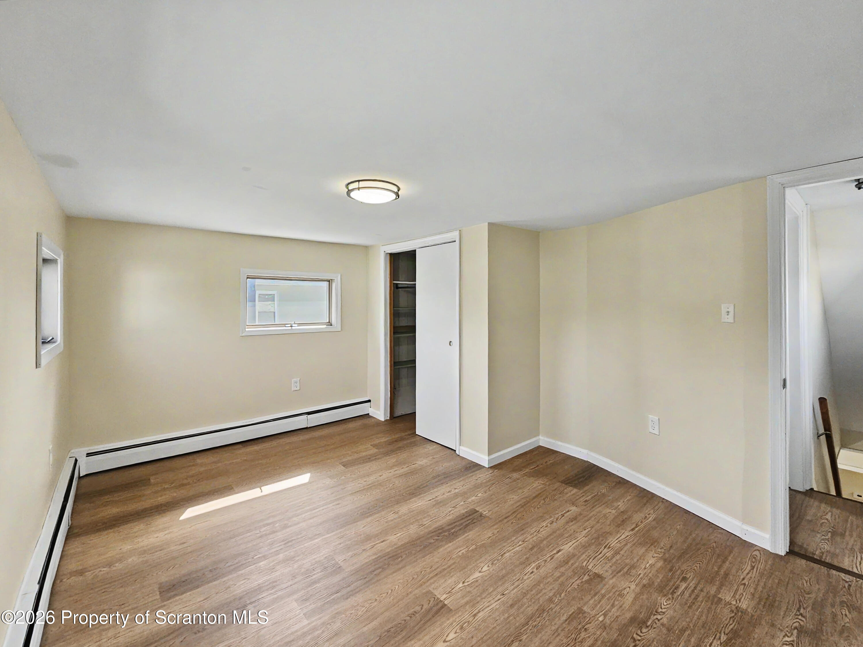 134 Lampman Street Avoca, PA 18641 - Photo 12 of 22 an empty room with wooden floor and windows