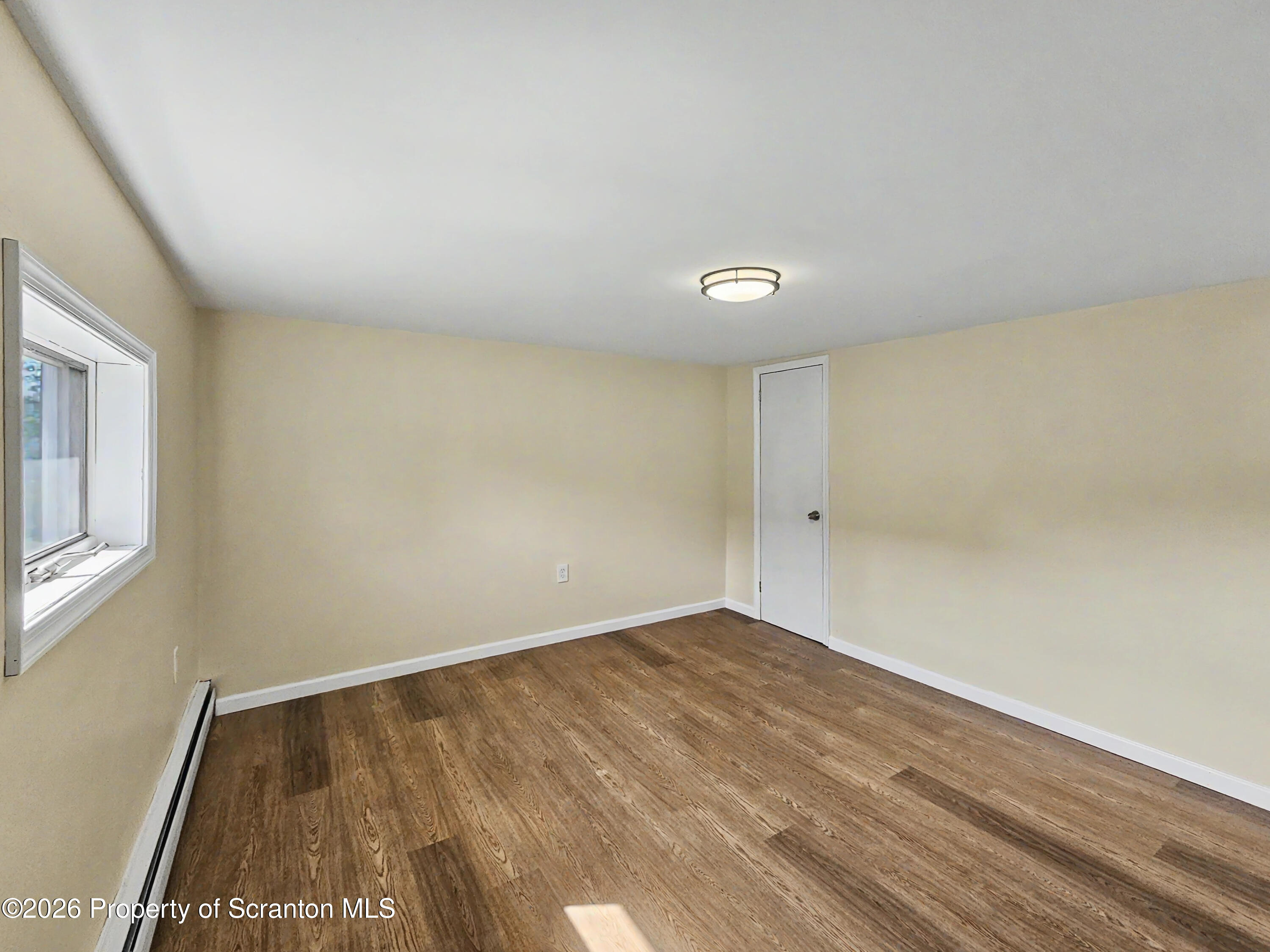 134 Lampman Street Avoca, PA 18641 - Photo 14 of 22 a view of an empty room with wooden floor and a window