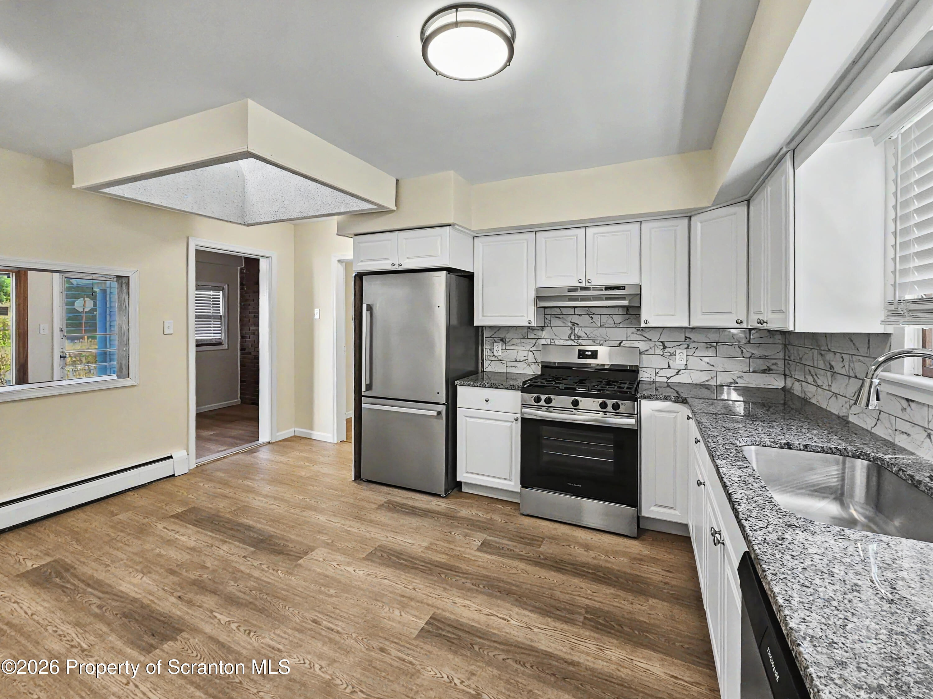 134 Lampman Street Avoca, PA 18641 - Photo 3 of 22 a kitchen with granite countertop a refrigerator stove top oven and sink