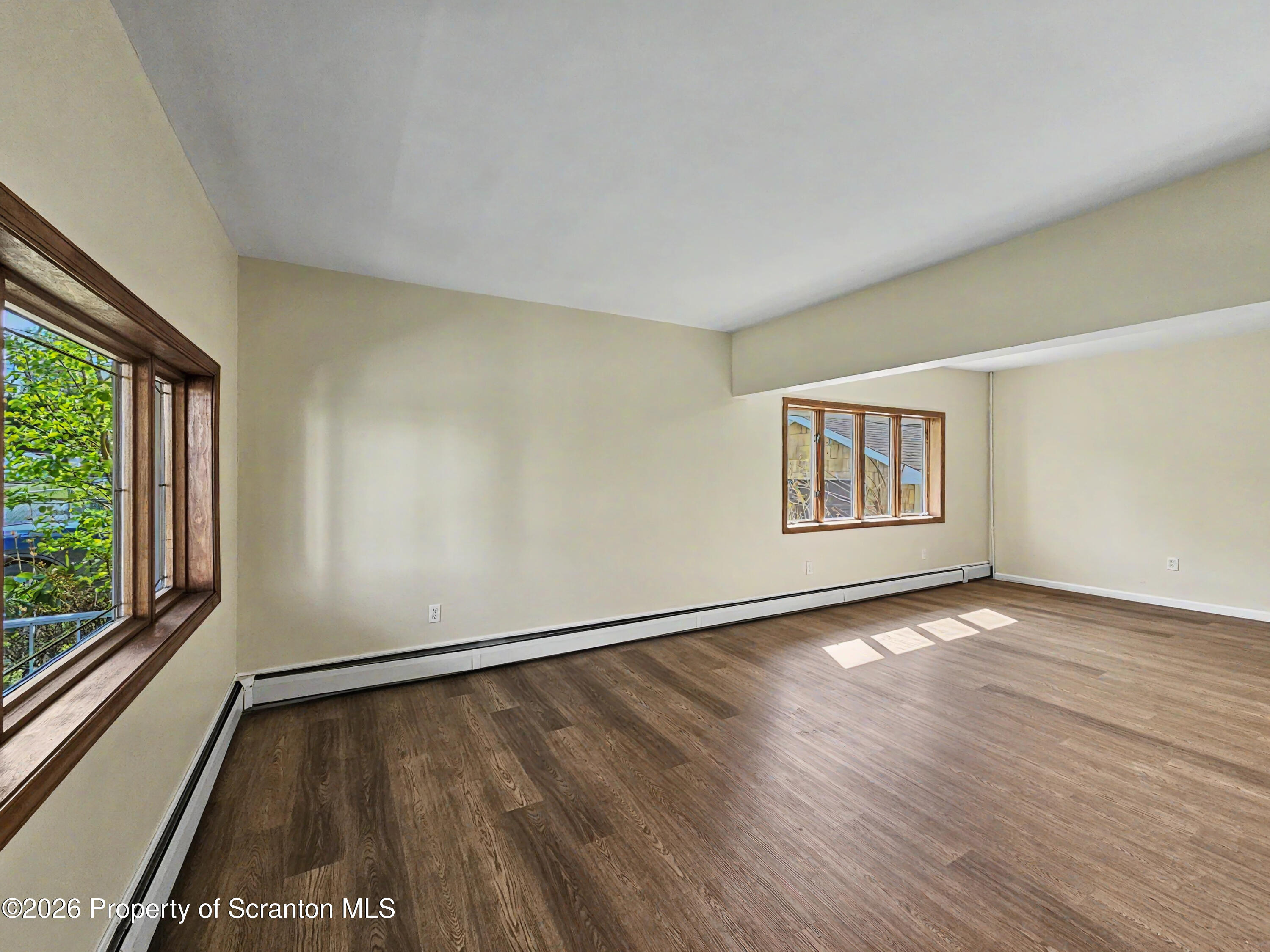134 Lampman Street Avoca, PA 18641 - Photo 6 of 22 an empty room with wooden floor and windows