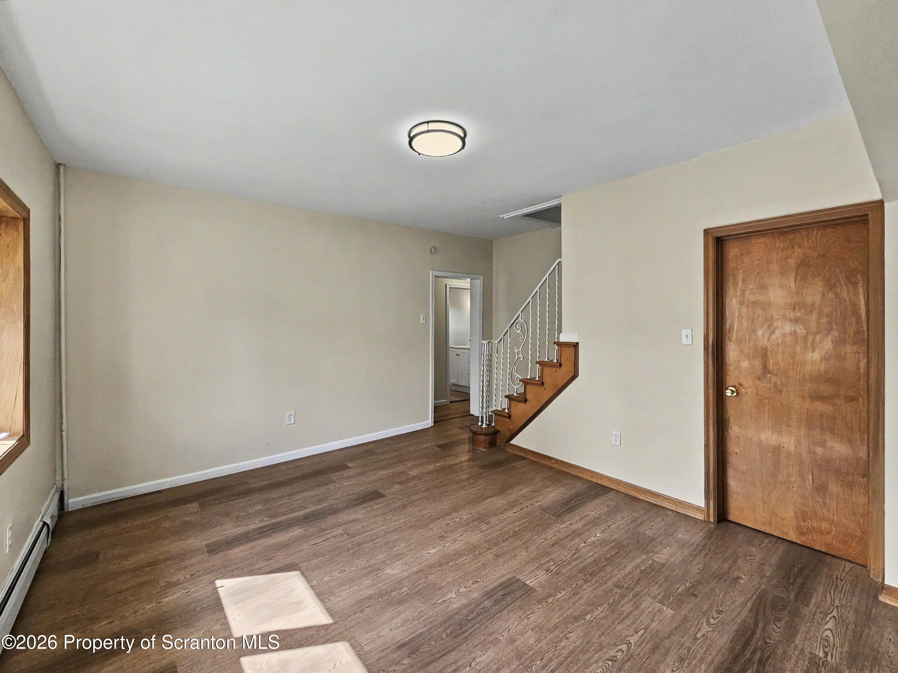 134 Lampman Street Avoca, PA 18641 - Photo 8 of 22 an empty room with wooden floor and stairs