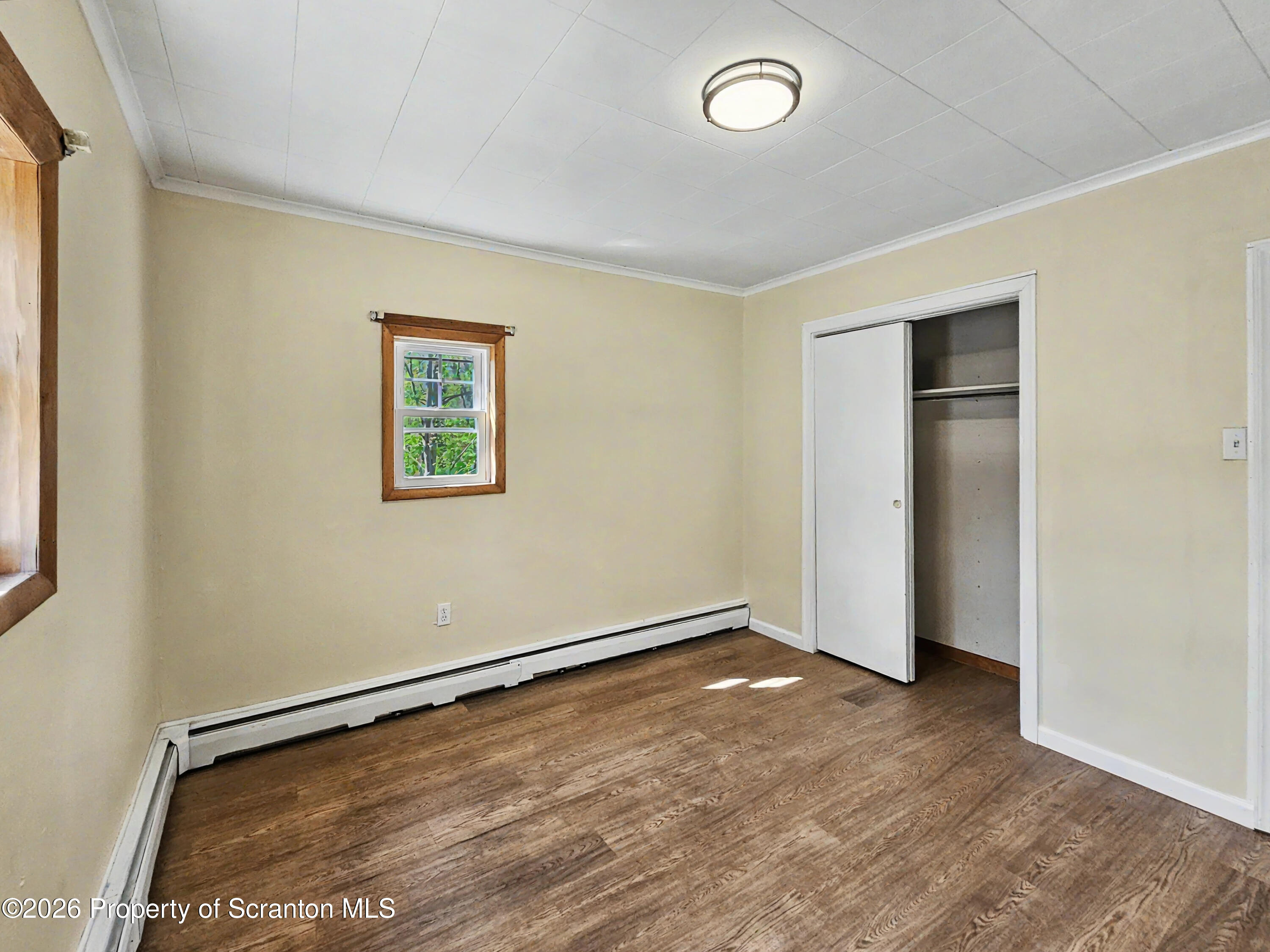 134 Lampman Street Avoca, PA 18641 - Photo 9 of 22 an empty room with wooden floor and window