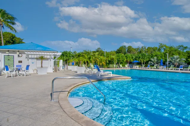 an outdoor living room with furniture and a flat screen tv