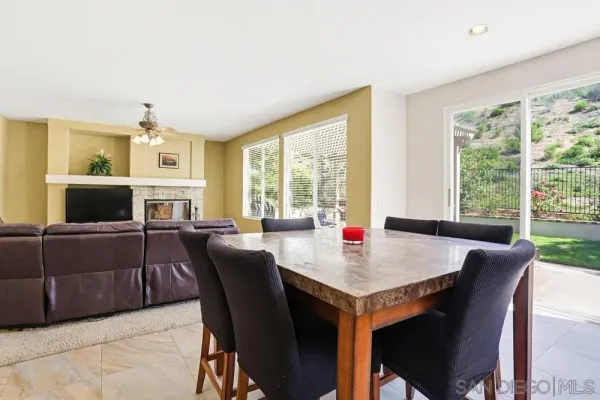 a kitchen with stainless steel appliances granite countertop a table chairs sink refrigerator and cabinets