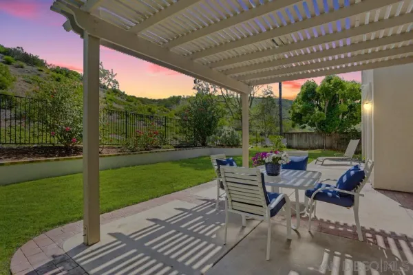 a view of a patio with a table chairs and a backyard