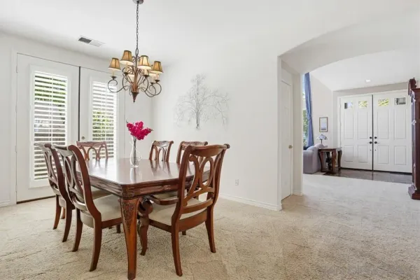 a view of a dining room with furniture and chandelier