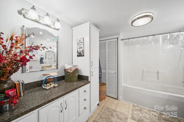 a bathroom with a granite countertop sink a toilet and shower