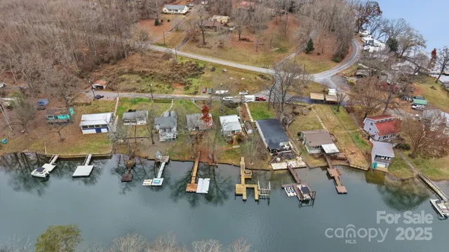 an aerial view of a wooden chairs and table in front of building