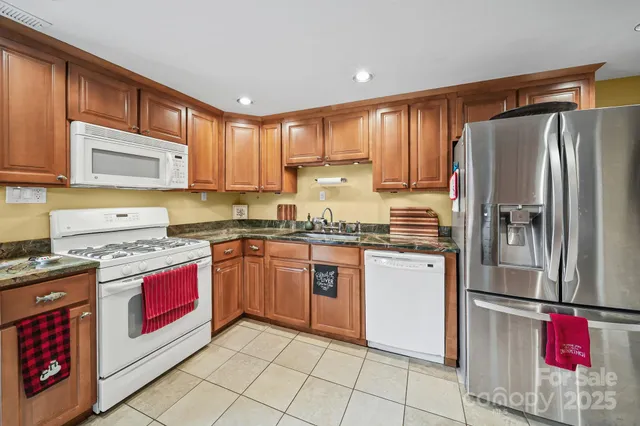 a kitchen with stainless steel appliances granite countertop a refrigerator and a stove top oven