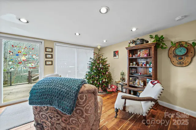 a living room with furniture a flat screen tv and a floor to ceiling window
