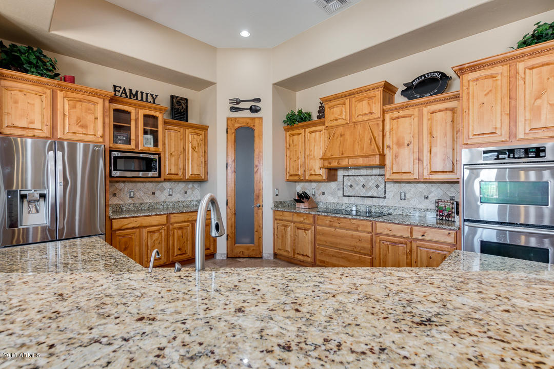 1982 North Goldfield Road Apache Junction, AZ 85119 - Photo 19 of 86 a large kitchen with stainless steel appliances granite countertop a stove a sink and a microwave