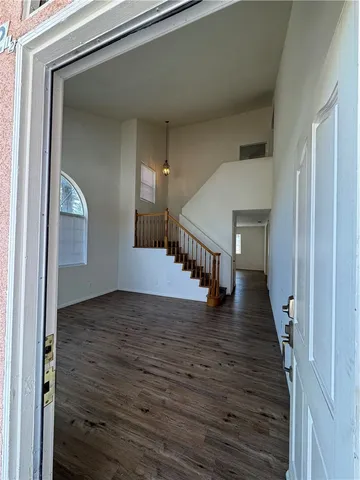 a view of a hallway with wooden floor and staircase