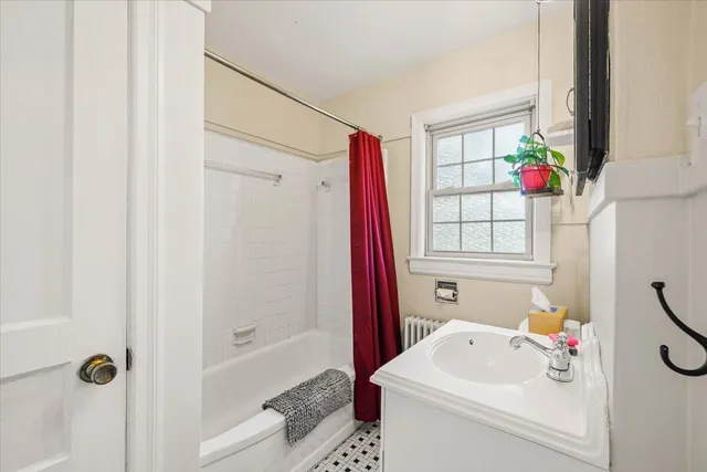 a bathroom with a sink a bath tub and a shower curtain