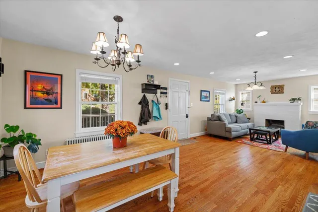 a view of a dining room with furniture a chandelier and wooden floor