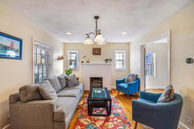 a living room with furniture a fireplace and a chandelier