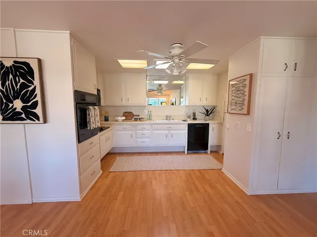 a large kitchen with a wooden floor and stainless steel appliances