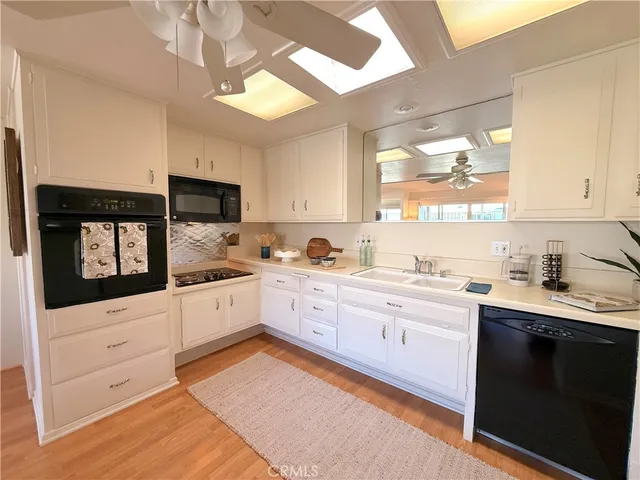 a kitchen with granite countertop a sink stainless steel appliances and cabinets