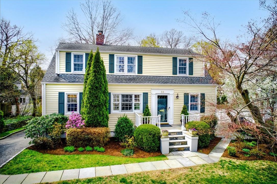 a front view of a house with yard and green space